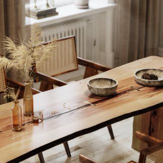 Wooden dining table and chairs. 3d rendering of rough edge plank dining table with glass vase and wooden utensils.